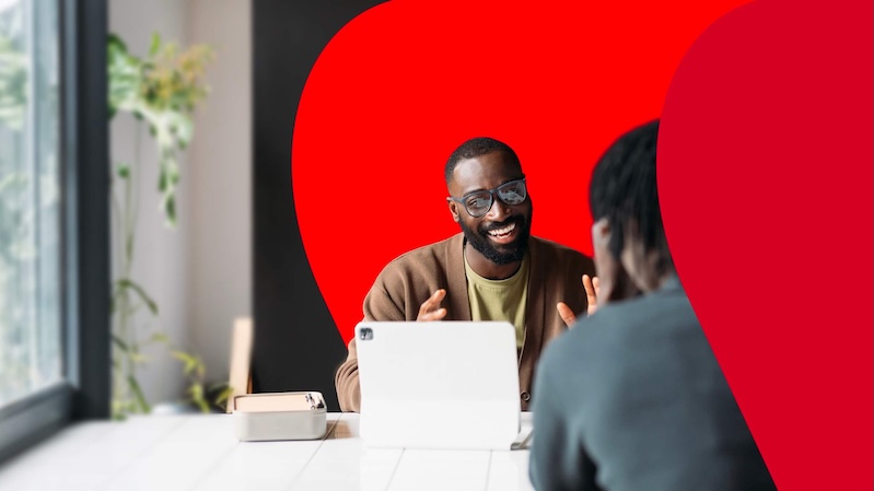 Stylized image of two people talking over a table.